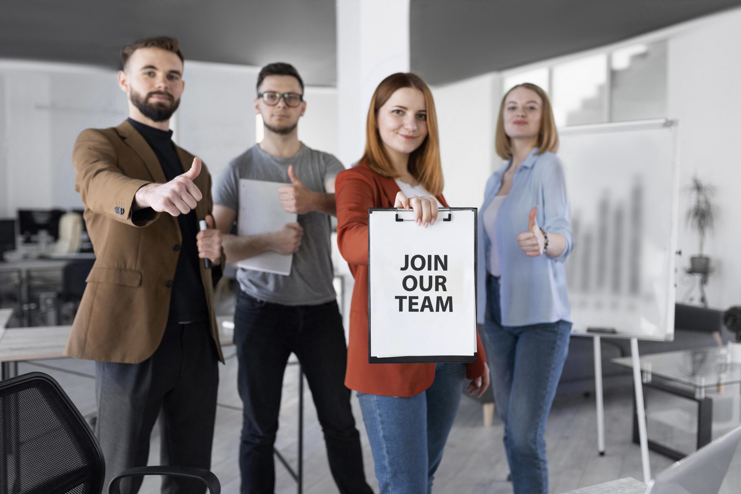 woman holding clipboard with join our team message